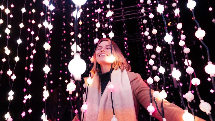 Woman grins among lights