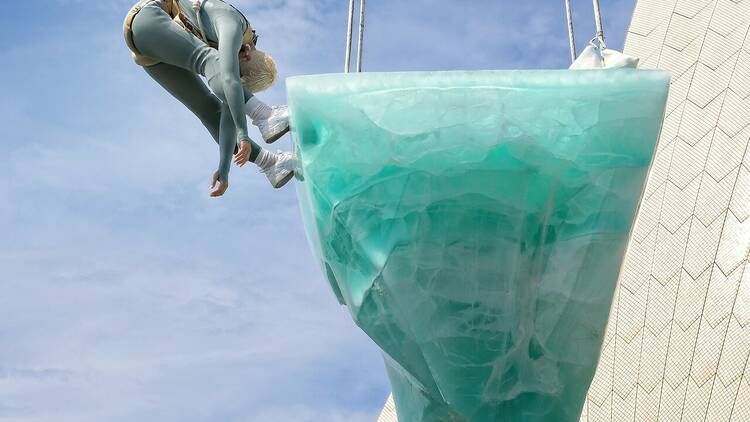 A performer balancing on a suspended block of ice 