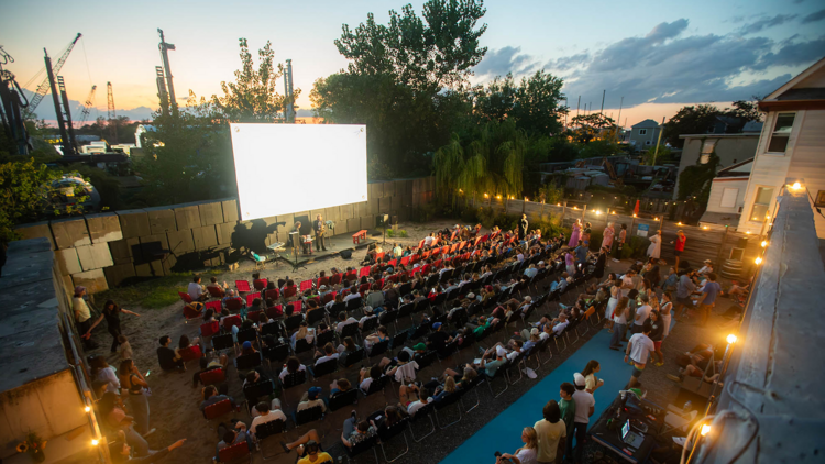 People watch a movie outdoors.