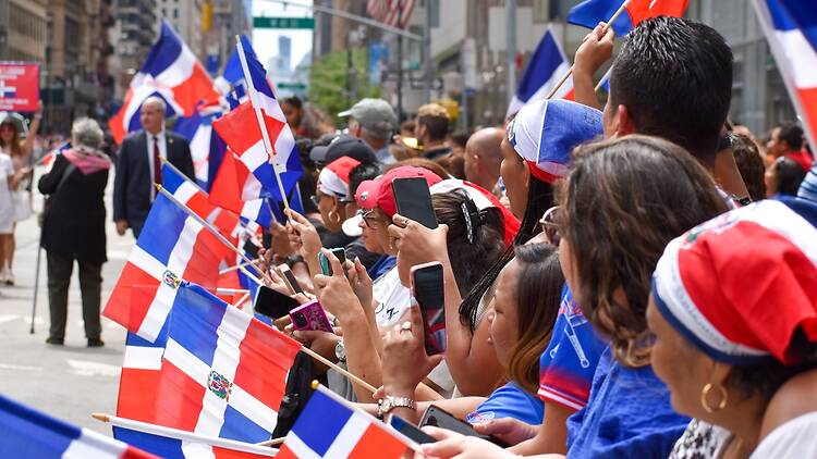 Dominican New Yorkers are seen waving flags during the annual Dominican Day Parade along Avenue of the Americas in New York City. Dominican New Yorkers are seen waving flags during the annual Dominican Day Parade along Avenue of the Americas in New York City.