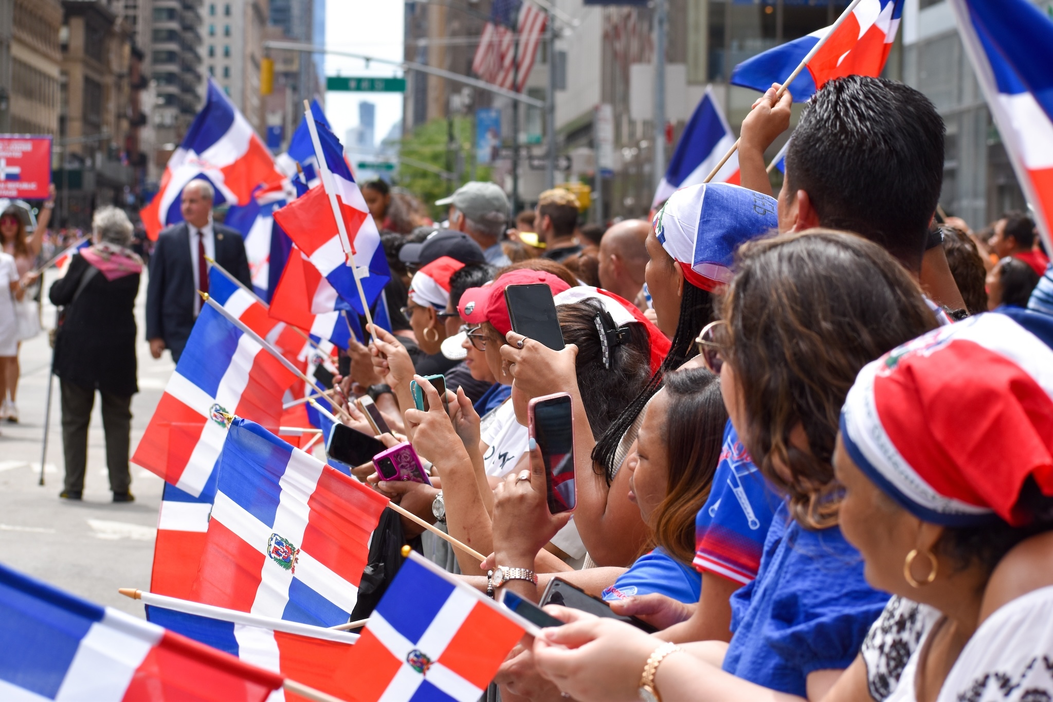 Dominican New Yorkers are seen waving flags during the annual Dominican Day Parade along Avenue of the Americas in New York City.