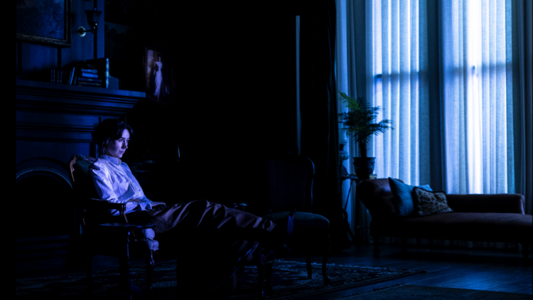 A woman sitting in a dark room 