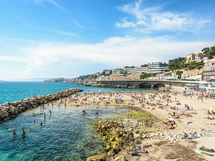 Marseille, France - May 19, 2018: People sunbathing and swimming on the Prophet beach, a very popular family beach located on the Kennedy corniche, on a hot and sunny spring day.