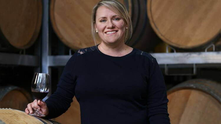 A woman in a room of wine barrels