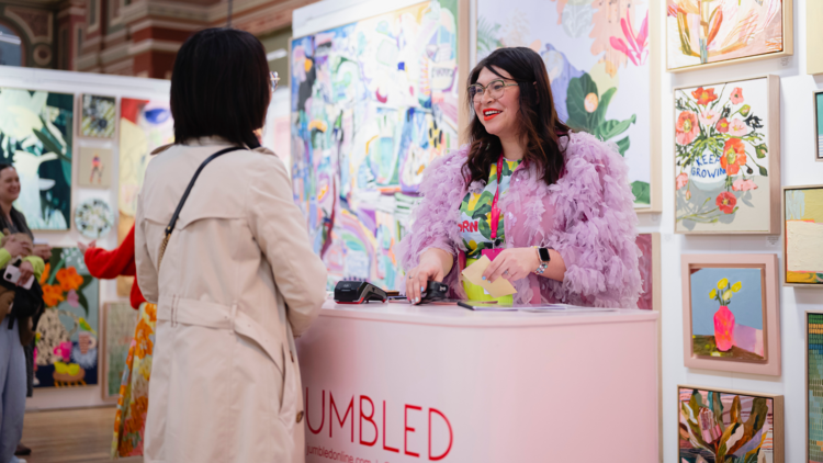 Customer talks to a stall holder at the affordable art fair