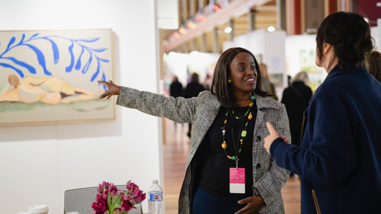 Customer talks to a stall holder at the affordable art fair