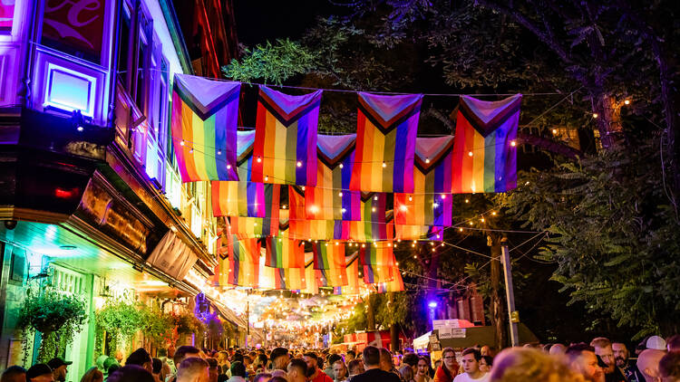 Manchester Pride nighttime event showing flags and people