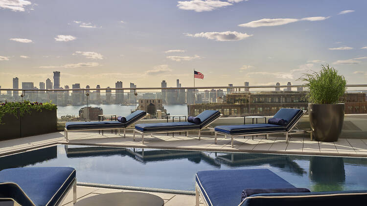 Rooftop picture from the top of Jimmy's at Modernhaus SoHo. Open air rooftop has blue lounge chairs and a pool