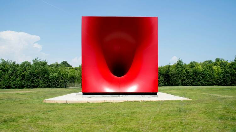 A red sculpture with a mysterious hole at its centre