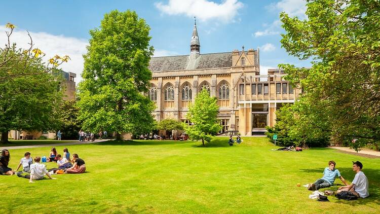 Oxford University with grass and students in the sunshine