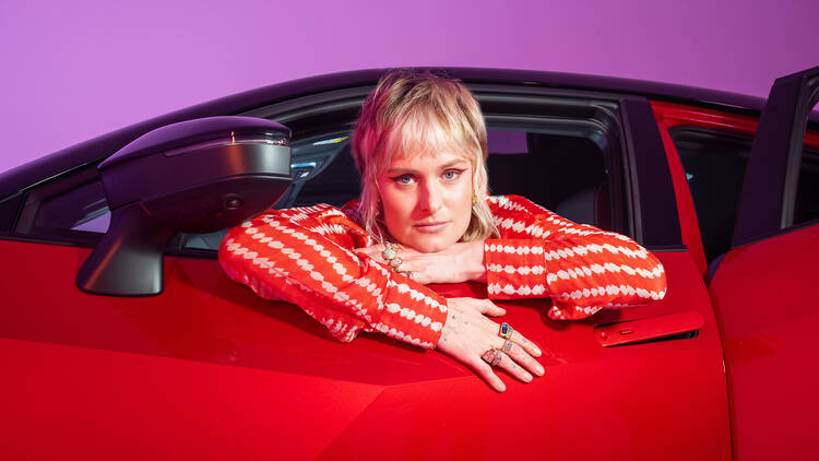 Millie Savage leaning out of the window of a Toyota C-HR car.