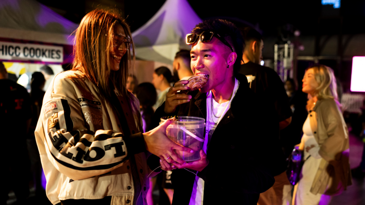 Two people eating at a festival 