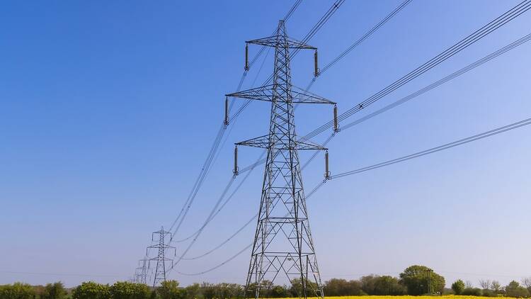 Electricity pylons over yellow field in the UK