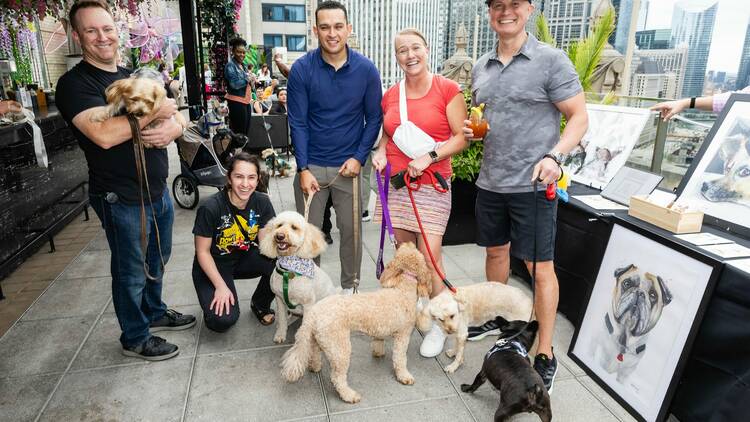 A group of people posing for a photo with dogs