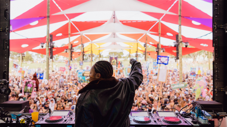 Artist on stage in front of colourful shade sails at Beyond the Valley