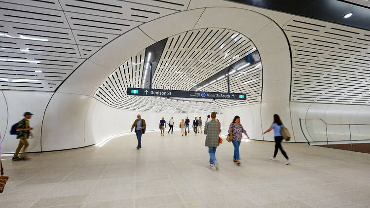 People walking through Victoria Cross Metro Station passageway towards exit to Denison Street and Miller Street South