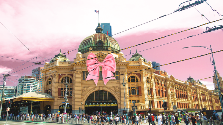 Flinders Street Station with a pink bow on it and a pink sky background.