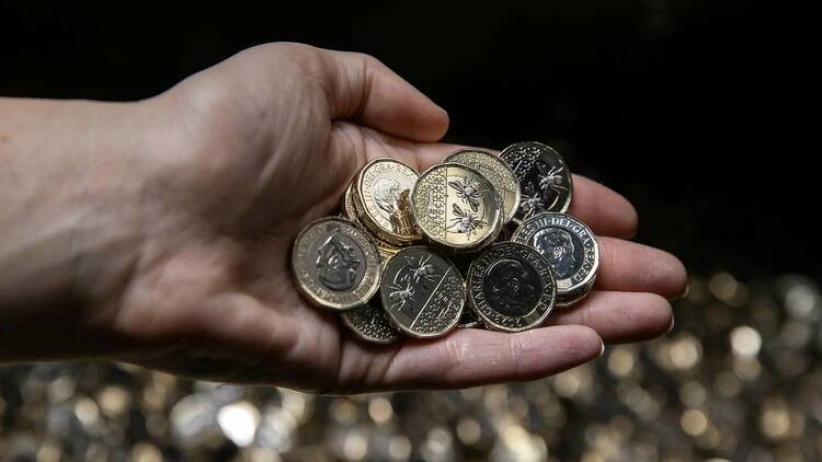 Image of hand holding new £1 coins. 