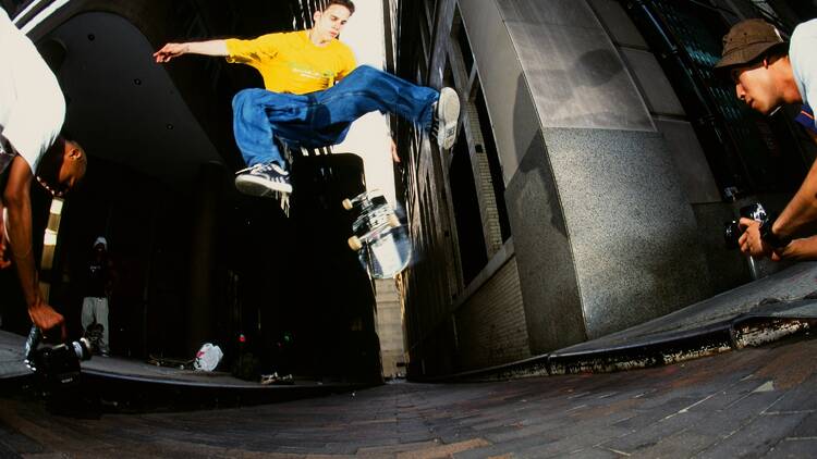 A skateboarder jumps off his board.