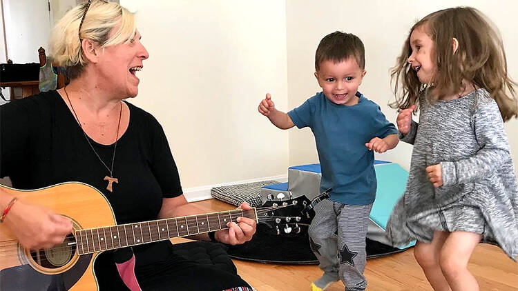 A woman leading a sing-along with two kids