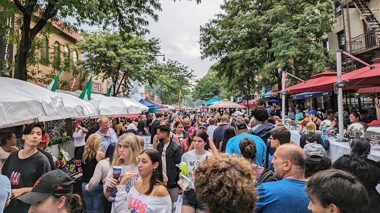 A large crowd of people standing in the street for the Ferragosto Festival