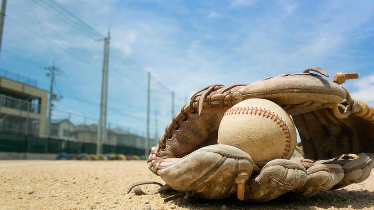 baseball in a glove on the ground