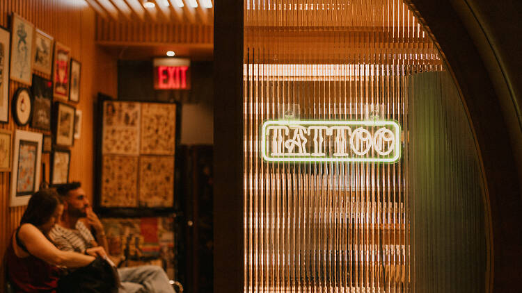 Glowing tattoo sign behind glass