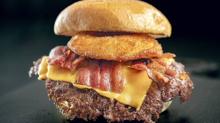 Burger with a fried onion ring, bacon and cheese