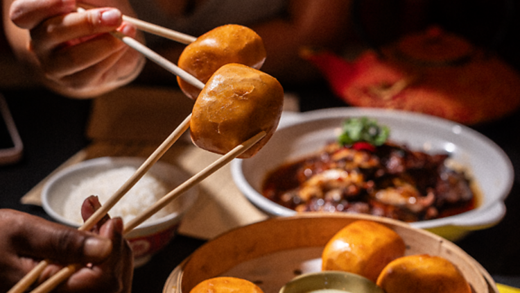 People holding man tous with choptick