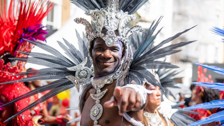 Man dressed in colourful carnival costume with silver feathers and gem stones