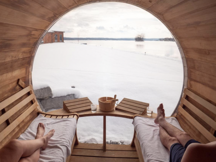 People in the sauna looking out over the snow covered terrace.                    