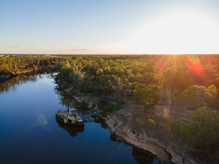 An aerial view of the Murray River with a paddlesteamer on the water. 