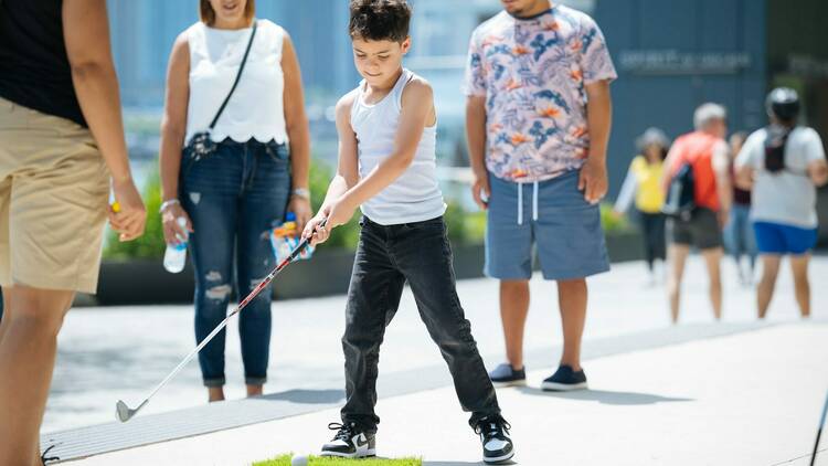 A child swinging a mini golf club