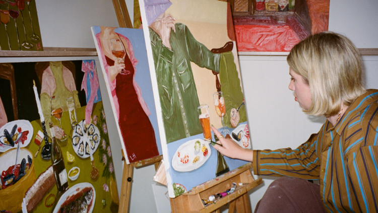 Libby Haines in front of a painting of various drinks