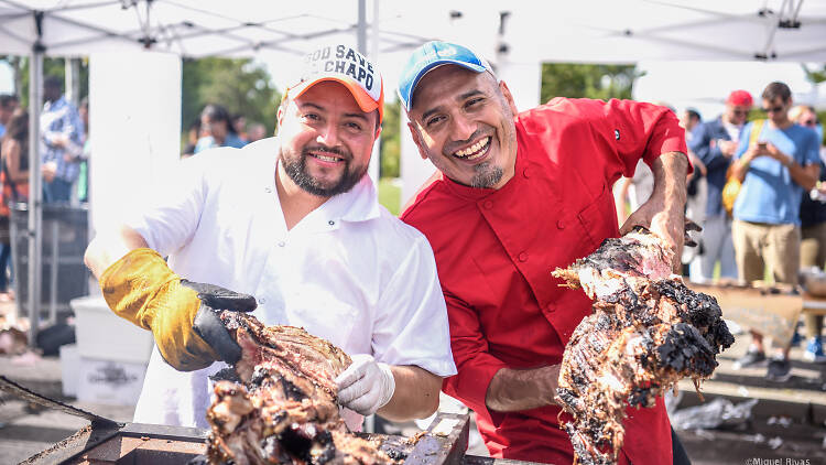 Two people holding cooked ribs