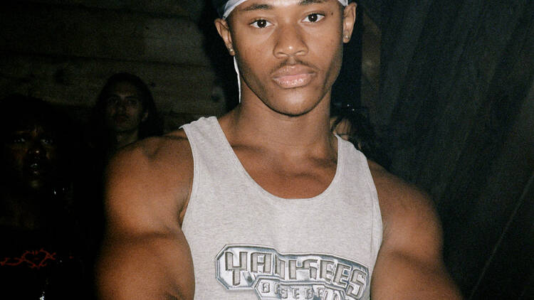 a person in a New York Yankees cap poses at Dick Appointment's 5 Year anniversary party