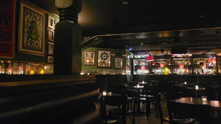 A dimly lit bar with framed pictures covering the walls.