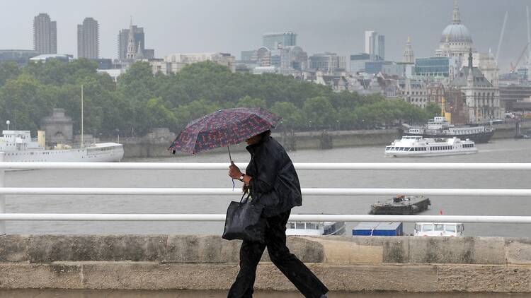 Wind and rain in London, with a person holding an umbrella