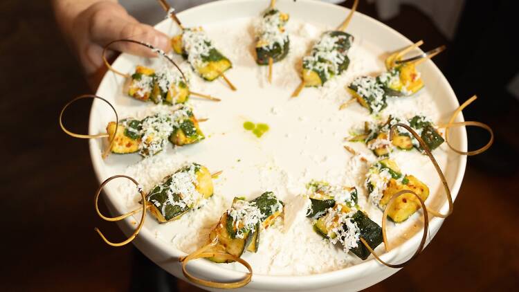 A chef holds a tray of food