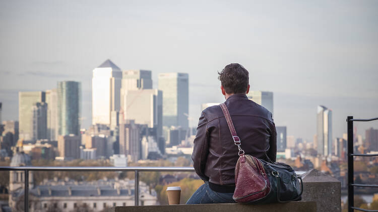 A solitary man in front of the London skyline