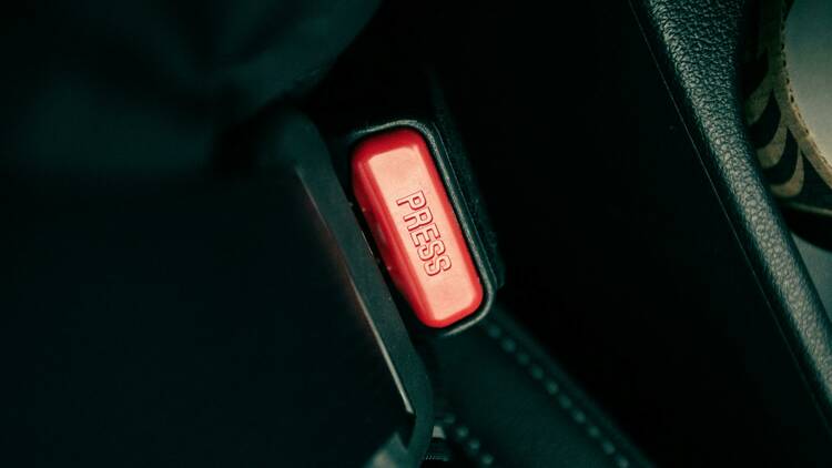 The PRESS button on a seatbelt