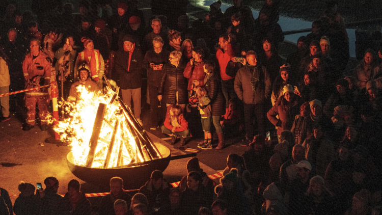 Singers gathered around a bonfire