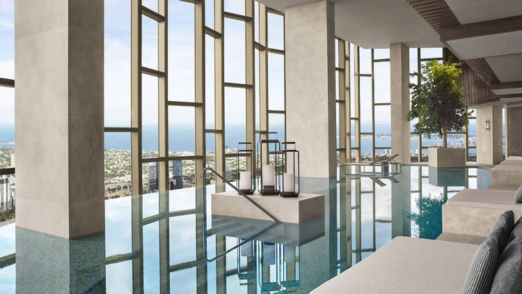 An infinity swimming pool with huge windows overlooking Melbourne.