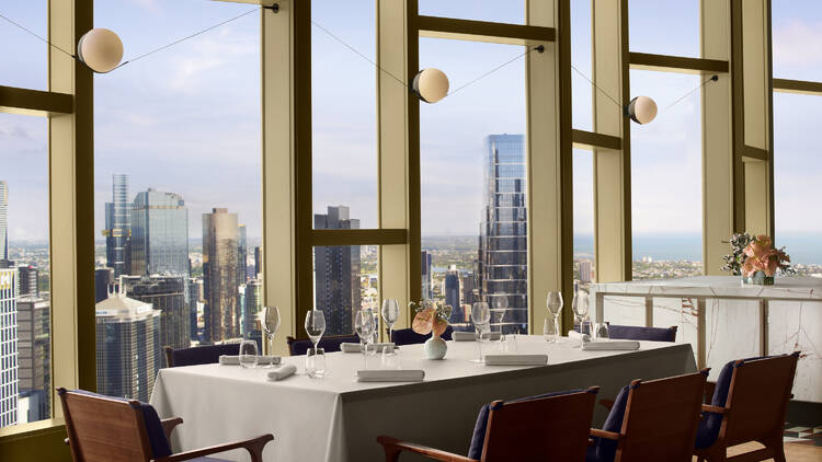 A dining table overlooking a city skyline. 