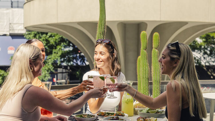 Women cheersing cocktails over brunch