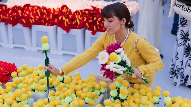 A woman selects a plush flower.