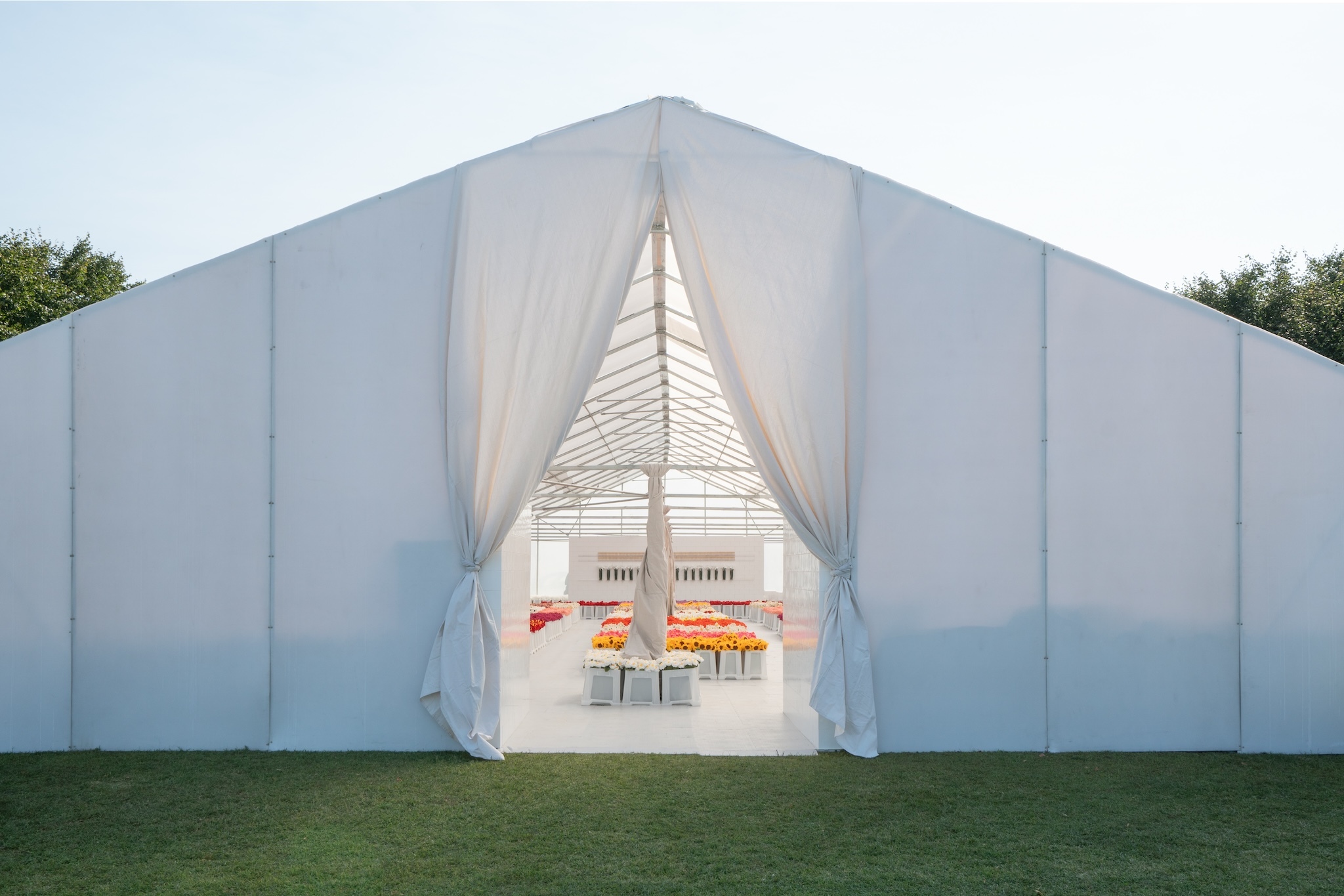 A large white tent filled with flowers.