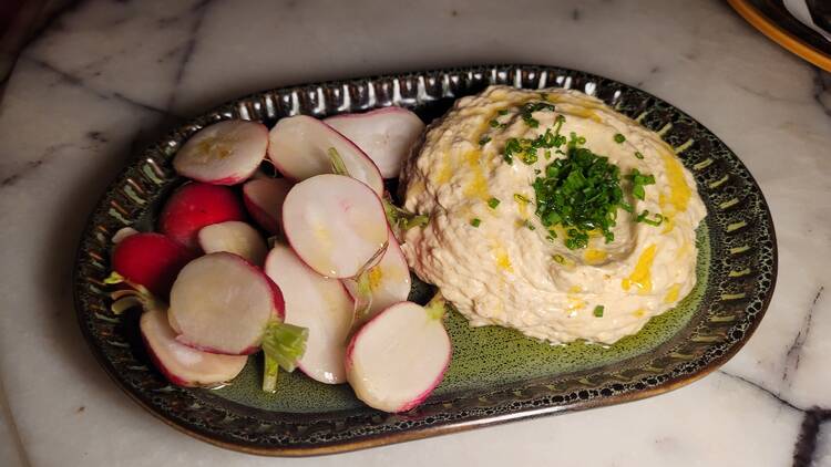 French onion dip and radishes on a green plate.