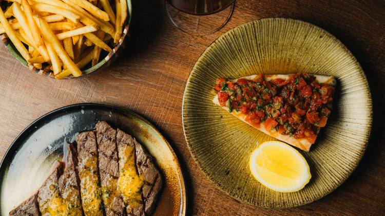 Minute steak, swordfish and chips on plates.