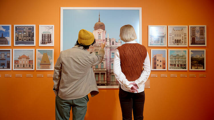 Two people peering at images from the exhibition